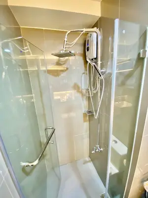 a shower with a glass door in a bathroom at Edin's Home in Manila