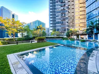 a large swimming pool in a city with tall buildings at Elegant and Modern 3BR Penthouse in Uptown BGC in Manila