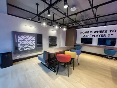 a room with a table and chairs and a large screen at Modern 1BR Stay near Solaire, Okada, near Airport in Manila