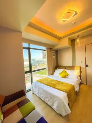 a bedroom with a bed and a large window at Modern 1BR Stay near Solaire, Okada, near Airport in Manila