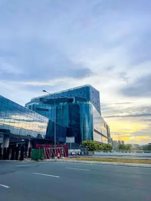 a large glass building on the side of a street at Modern 1BR Stay near Solaire, Okada, near Airport in Manila
