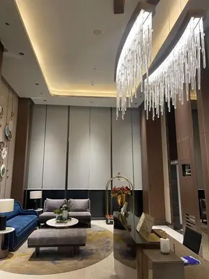 a lobby with a couch and a chandelier at Modern 1BR Stay near Solaire, Okada, near Airport in Manila