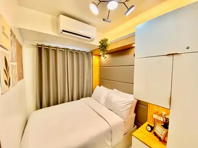 a small bedroom with a bed and a window at Calix Suite in Manila