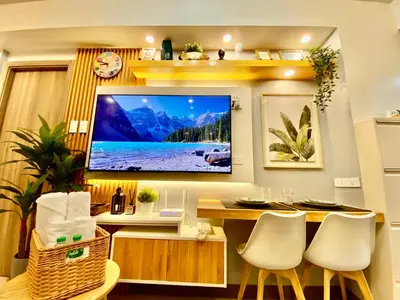 a living room with a flat screen tv on a wall at Calix Suite in Manila