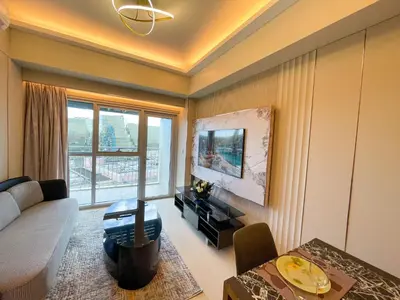 a living room with a couch and a table at Luxury and Modern 1 Bedroom near Solaire, Okada in Manila