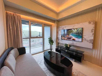 a living room with a couch and a table at Luxury and Modern 1 Bedroom near Solaire, Okada in Manila