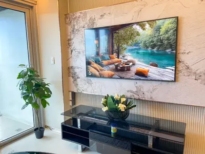 a living room with a tv hanging on a wall at Luxury Suites near Okada, Solaire, City of Dreams in Manila