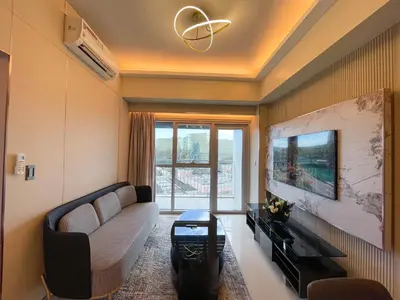 a living room with a couch and a tv at Luxury Suites near Okada, Solaire, City of Dreams in Manila