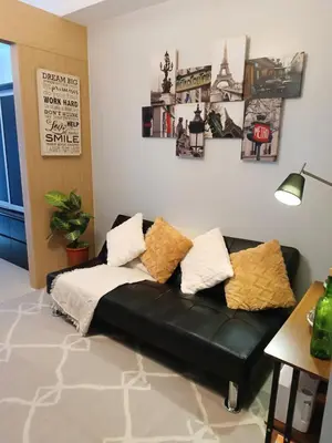a black leather couch in a living room with pictures on the wall at Condotels near NAIA in Manila