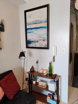 a living room with a table and a picture on the wall at Condotels near NAIA in Manila