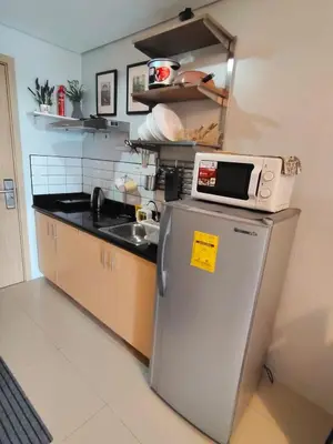 a kitchen with a microwave on top of a refrigerator at Condotels near NAIA in Manila