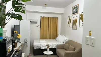 a small room with a bed and a chair at Furnished Condo Unit-Green2 PoolWifiNetflix in Dasmariñas
