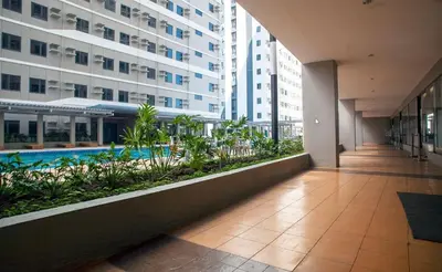 a hallway in a building with a pool and buildings at Furnished Condo Unit-Green2 PoolWifiNetflix in Dasmariñas