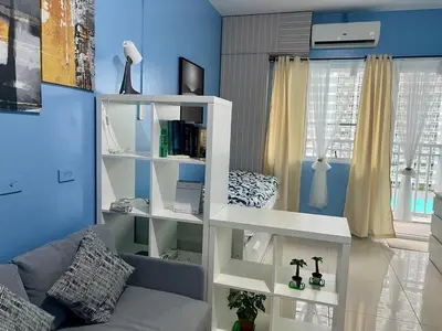 a living room with a white book shelf at Condo Near World Trade, Star City and PICC - Amazing Breeze in Manila