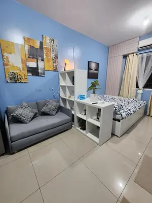 a bedroom with a couch and a bed and a desk at Condo Near World Trade, Star City and PICC - Amazing Breeze in Manila