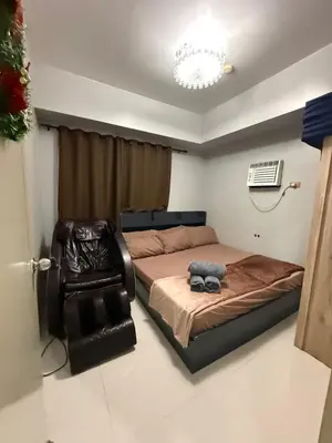 a bedroom with a bed and a chair at Staycation By Abii in Manila