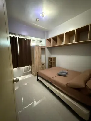 a bedroom with a large bed and a window at Staycation By Abii in Manila