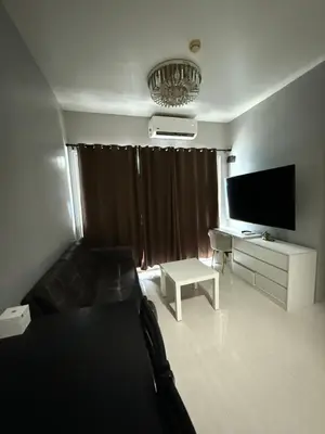 a living room with a flat screen tv and a couch at Staycation By Abii in Manila