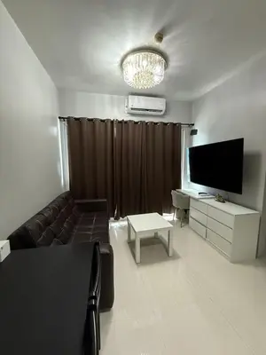 a living room with a couch and a flat screen tv at Staycation By Abii in Manila