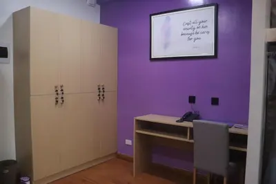 a room with a desk and a purple wall at YMCA Makati in Manila