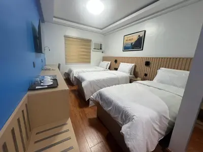 a hotel room with two beds and a desk at YMCA Makati in Manila