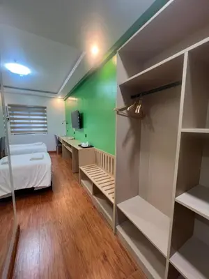 a bedroom with a bed and a green wall at YMCA Makati in Manila