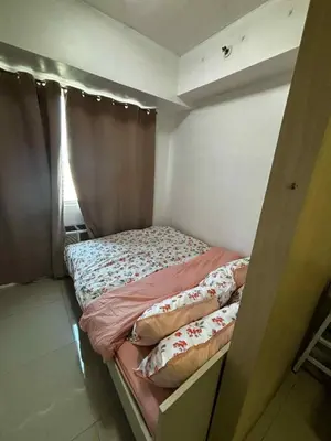 a small bed in a room with a window at Elizas place in Manila