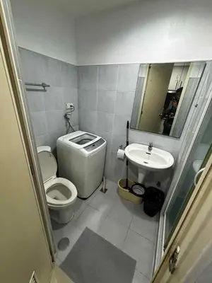 a small bathroom with a toilet and a sink at Elizas place in Manila