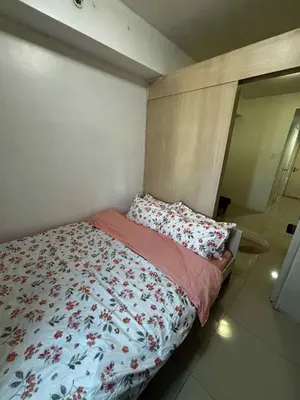 a bedroom with a bed with red flowers on it at Elizas place in Manila
