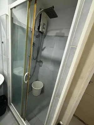 a shower with a glass door in a bathroom at Elizas place in Manila