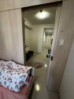 a small room with a bed and a mirror at Elizas place in Manila
