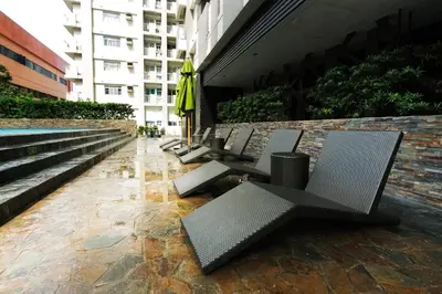 a row of chairs and umbrellas sitting next to a building at FLAT ESHRA - Cozy Bright 1-BR in Manila