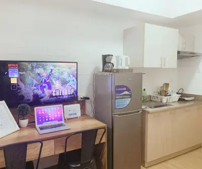 a kitchen with a table with a laptop computer on it at FLAT ESHRA - Cozy Bright 1-BR in Manila