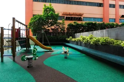 a playground with a slide and play equipment in front of a building at FLAT ESHRA - Cozy Bright 1-BR in Manila