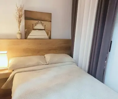 a bedroom with a bed with a picture on the wall at FLAT ESHRA - Cozy Bright 1-BR in Manila