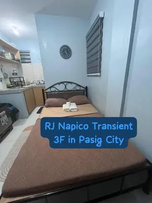 a bedroom with a bed with a clock on the wall at RJ Wallfan Studio Transient in Napico, Lifehomes Pasig City in Manila