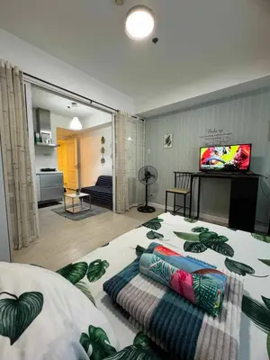 a bedroom with a large bed with pillows on it at azure 1bedroom pool view in Manila