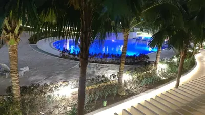 an overhead view of a swimming pool with palm trees at azure 1bedroom pool view in Manila