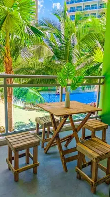 a picnic table and benches with a potted plant on it at azure 1bedroom pool view in Manila