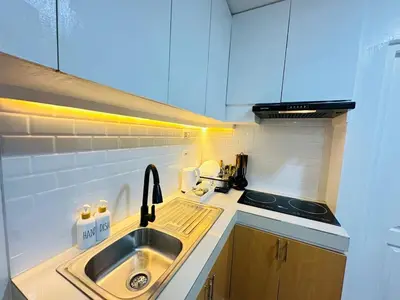 a small kitchen with a sink and a stove at Unwind Oasis Two Bedroom Free Pool Access in Manila