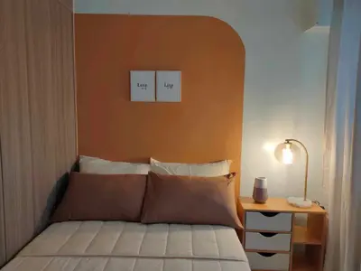 a bedroom with a bed with two pictures on the wall at shore 1bedroom with balcony in Manila
