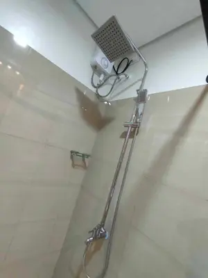 a shower in a bathroom with a glass shower stall at shore 1bedroom with balcony in Manila
