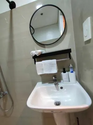 a bathroom with a sink and a mirror at shore 1bedroom with balcony in Manila