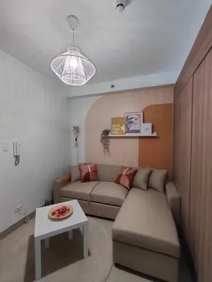 a living room with a couch and a table at shore 1bedroom with balcony in Manila