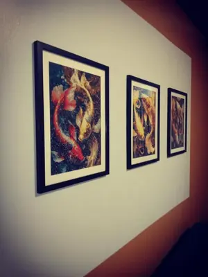 three framed paintings on a white wall at Shore residences Tower D pool view Unit in Manila