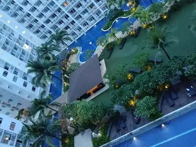 an overhead view of a building with a pool and trees at Shore residences Tower D pool view Unit in Manila