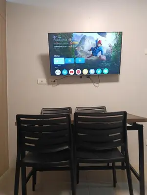 two chairs and a table with a tv on a wall at Shore residences Tower D pool view Unit in Manila