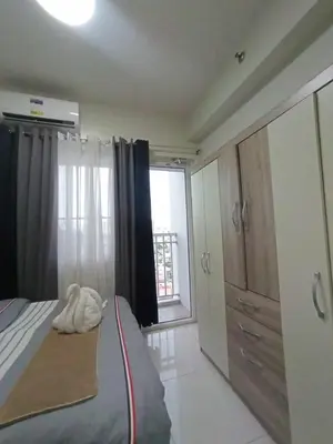 a bedroom with a bed and a large window at Breeze Residences pasay near naia airport in Manila