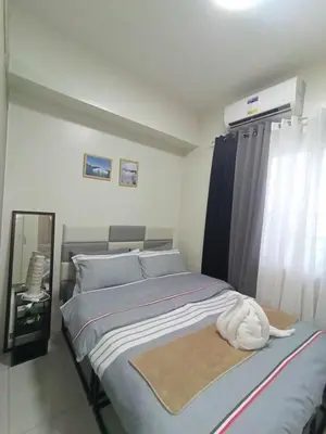 a bedroom with a bed and a air conditioner at Breeze Residences pasay near naia airport in Manila