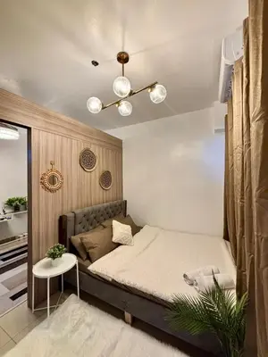 a small bedroom with a bed and a table at Staycation by the Shore in Manila